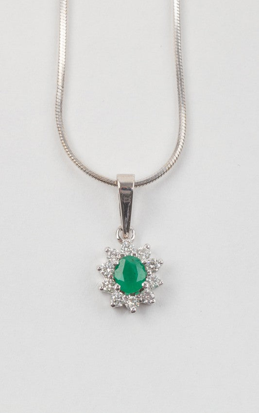 White gold entourage pendant with emerald and diamonds on a white gold necklace