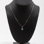White gold entourage pendant with emerald and diamonds on a white gold necklace