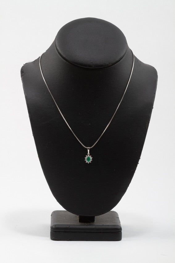 White gold entourage pendant with emerald and diamonds on a white gold necklace