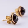 Gold earrings, each with a garnet