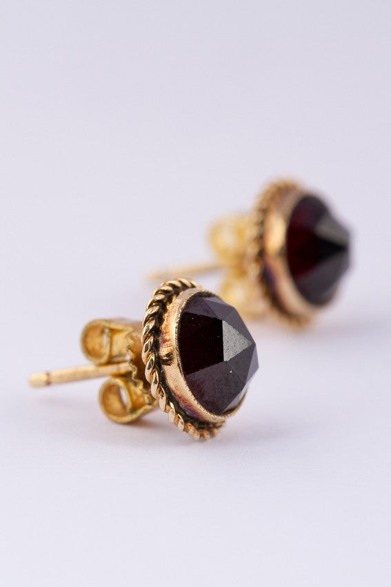 Gold earrings, each with a garnet