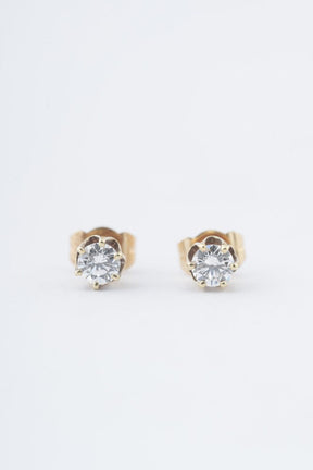 Gold solitaire earrings with a brilliant in each one