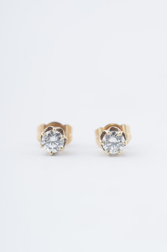 Gold solitaire earrings with a brilliant in each one