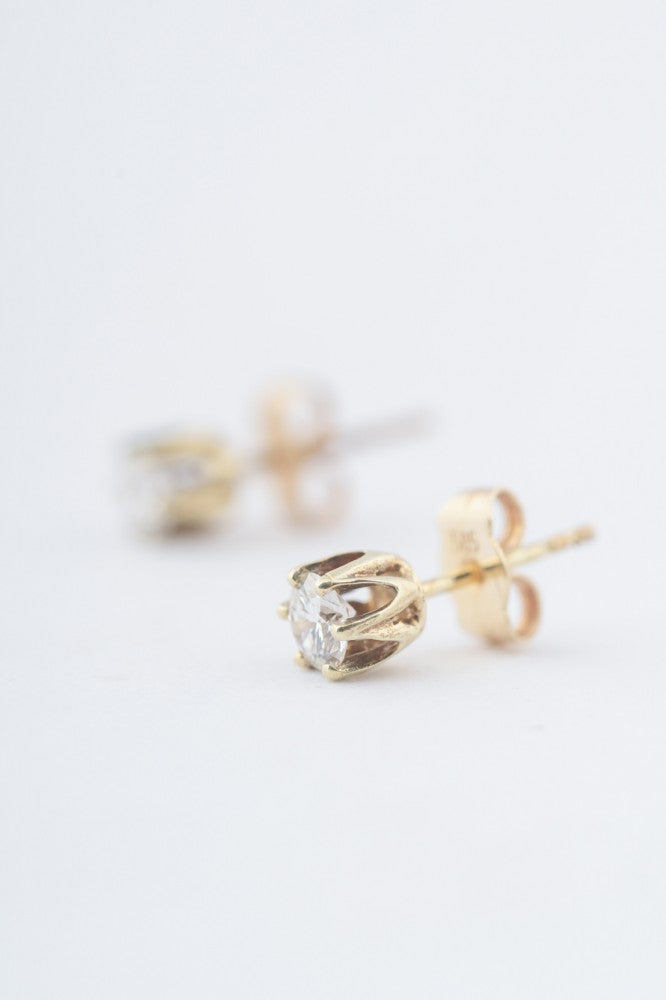 Gold solitaire earrings with a brilliant in each one