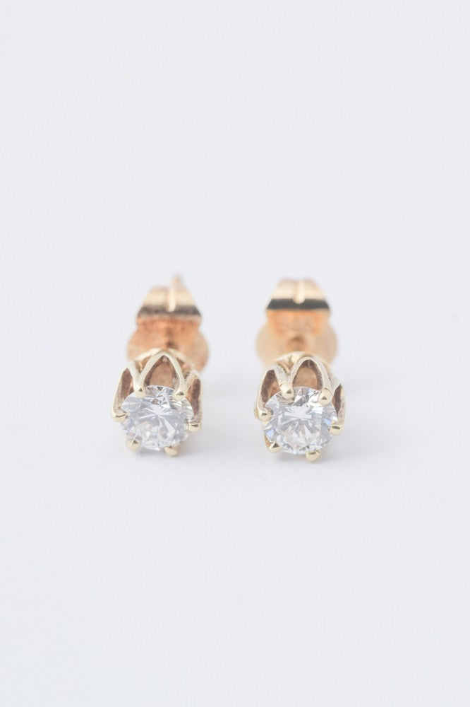 Gold solitaire earrings with a brilliant in each one