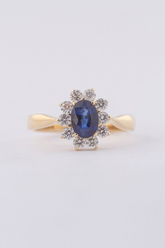 Gold entourage ring with sapphire and diamonds