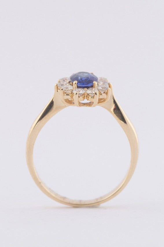 Gold entourage ring with sapphire and diamonds