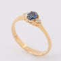 Gold row ring with sapphire and 2 brilliants