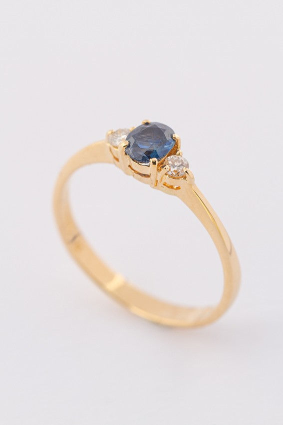 Gold row ring with sapphire and 2 brilliants