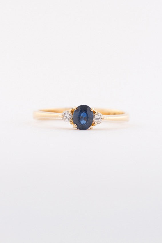 Gold row ring with sapphire and 2 brilliants