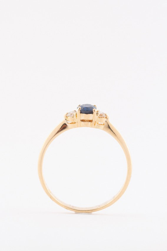 Gold row ring with sapphire and 2 brilliants