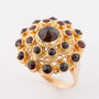 Gold double entourage ring with garnets