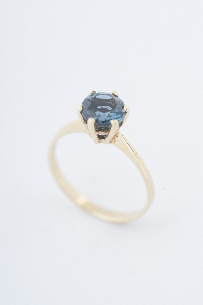 Gouden solitair ring met een london blue topaas