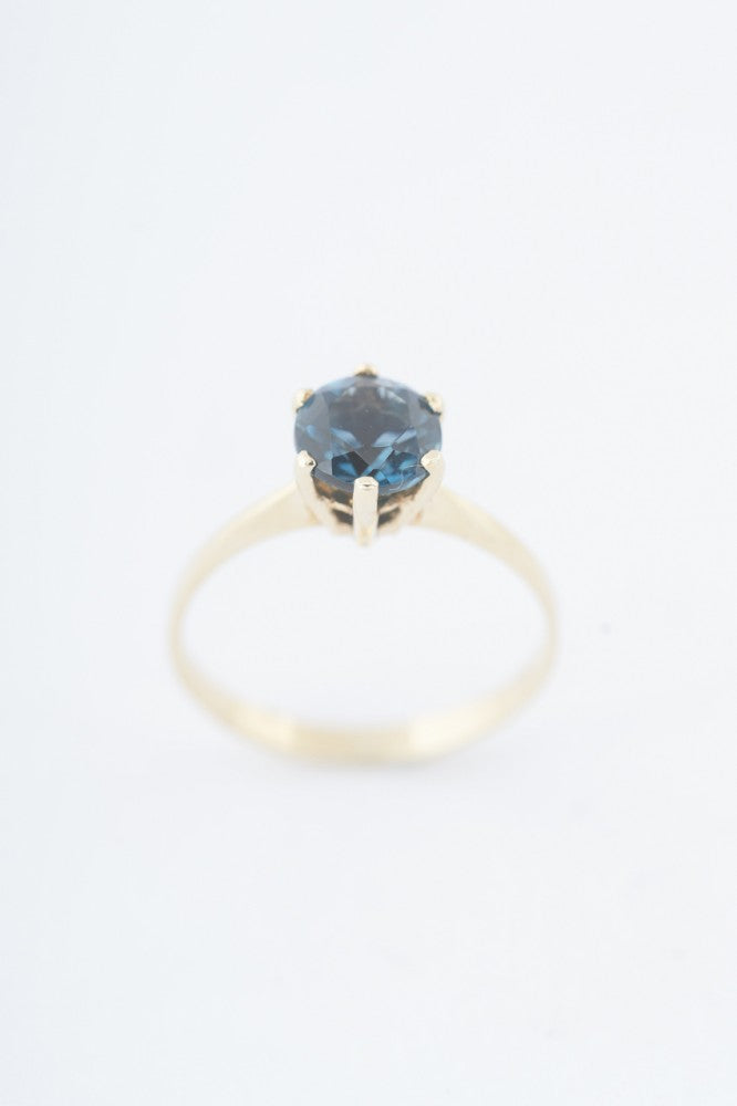 Gouden solitair ring met een london blue topaas