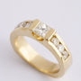 Gold band ring with a princess cut round diamonds