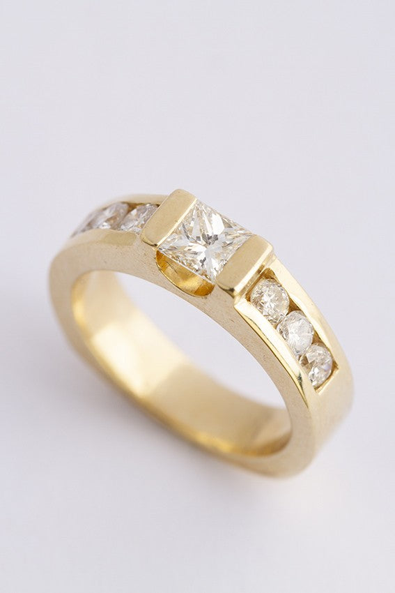 Gold band ring with a princess cut round diamonds