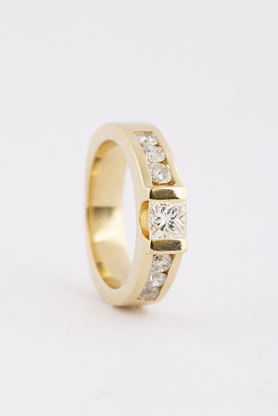 Gold band ring with a princess cut round diamonds