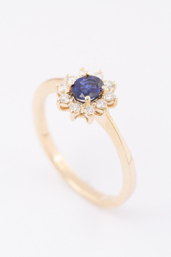 Gold entourage ring with sapphire and diamonds