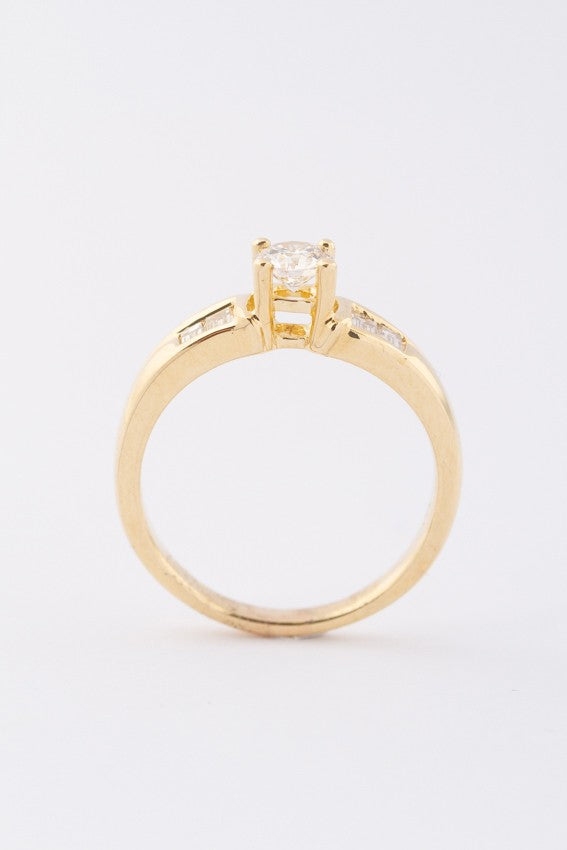 Gouden rij ring met een briljant en baguette geslepen diamanten