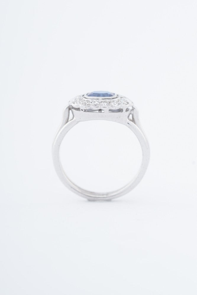 White gold entourage ring with a cushion sapphire and diamonds
