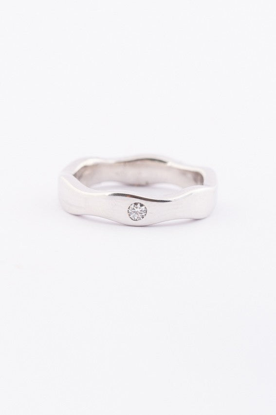 Wit gouden golvende ring met een briljant