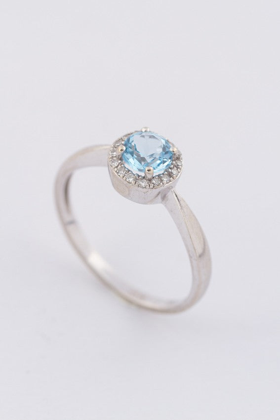 Wit gouden entourage ring met een blauwe topaas en briljanten