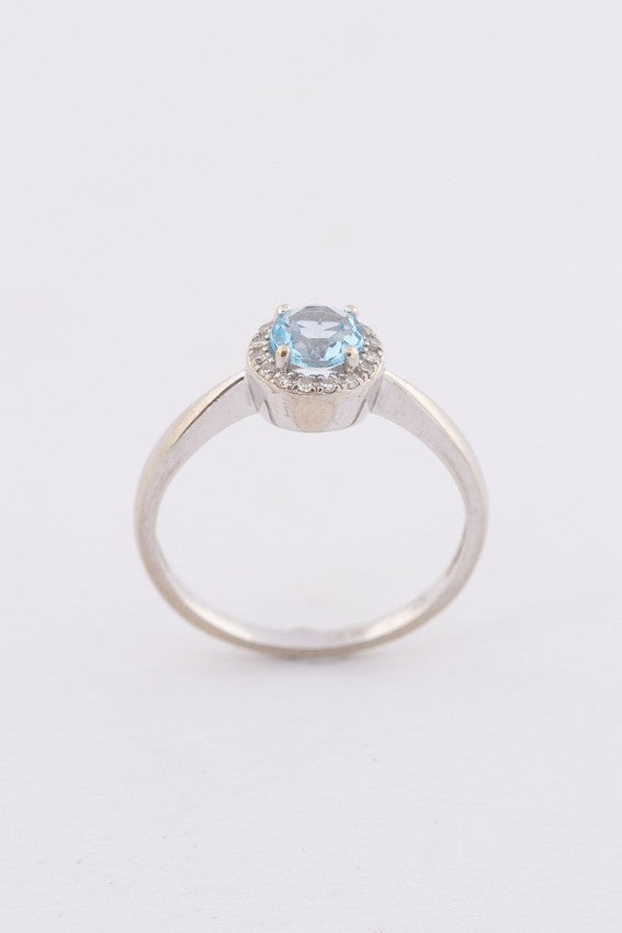 Wit gouden entourage ring met een blauwe topaas en briljanten