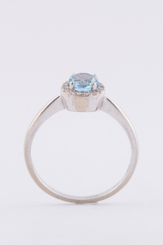 Wit gouden entourage ring met een blauwe topaas en briljanten